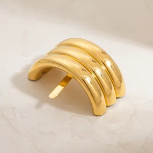 Detail view of a vintage C-shaped gold-plated stainless steel hair clip with mirror finish