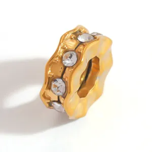 Detailed macro view of a gold-plated wavy spacer bead featuring inlaid clear rhinestones