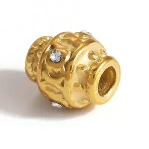 Close-up detail of a textured gold-plated stainless steel spacer bead with inlaid crystals