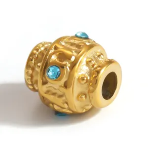 Macro detail of ornate gold-plated stainless steel spacer bead with blue rhinestones