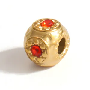 Detailed close-up of a gold-plated stainless steel spacer bead with red crystals