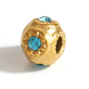 Detail of a gold-plated stainless steel spacer bead with sparkling blue crystals.