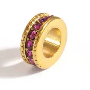 Detailed macro shot of a gold-plated stainless steel spacer bead with purple crystals