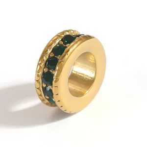 Detailed macro view of gold plated stainless steel spacer bead with inset green stones