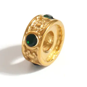 Detailed view of gold-plated stainless steel spacer bead with green stones and texture
