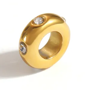 Detailed view of a gold-plated stainless steel spacer bead with embedded crystals