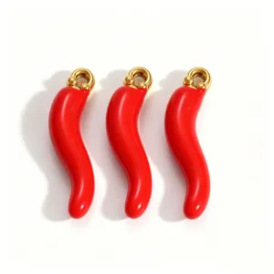 Close-up of three red chili pepper pendants with gold-plated ring attachments for DIY jewelry