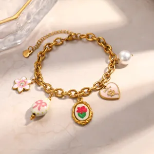Detailed view of gold-plated stainless steel charm bracelet with rose and heart charms
