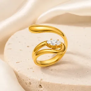 Detalle de un anillo envolvente de acero dorado con piedra de circonita marquesa