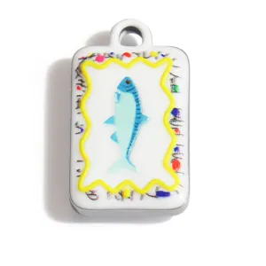 Detalle de un colgante de acero inoxidable con motivo de pez y diseño veraniego para joyería.
