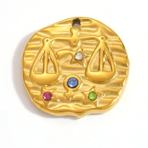 Gros plan d'un pendentif signe Balance en or avec des cristaux colorés étincelants.