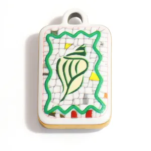 Primer plano de un colgante de acero con tema oceánico y diseño de concha en mosaico