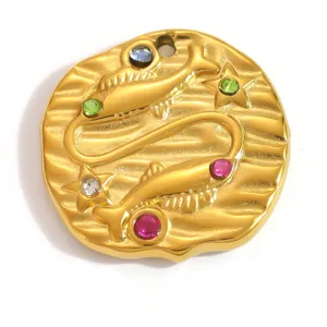 Gros plan d'un pendentif Poissons plaqué or 18 carats avec cristaux colorés.