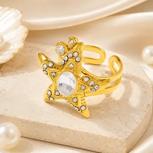 Primer plano de un anillo de estrella de mar bañado en oro con circonitas brillantes
