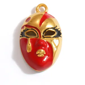 Detailed macro view of a gold-plated stainless steel opera mask pendant with red enamel