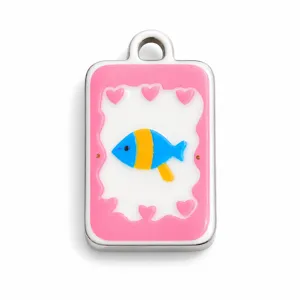 Macro de un simpático pez de esmalte de colores y corazones en colgante de acero