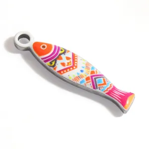 Primer plano de un colgante de pez colorido en acero inoxidable para la creación de joyas