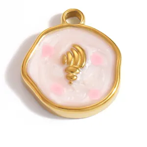 Makro-Detail eines goldenen Edelstahl-Muschelanhängers mit rosa Emaille-Tropföl.