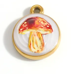 Detailaufnahme eines Pilz-Anhängers aus goldenem Edelstahl mit rot-gelber Illustration.