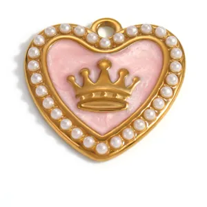 Macro view of a heart-shaped golden pendant featuring pink enamel and a crown detail