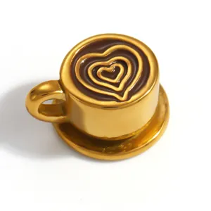 Close-up of a gold-plated coffee cup pendant featuring heart-shaped latte art detail.