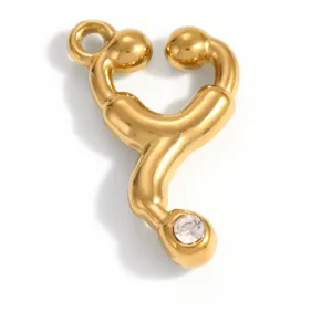 Detailed macro view of a gold-plated stethoscope pendant with a clear crystal inlay.