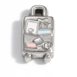 Macro detail of silver suitcase charm with enamel accents and sparkling cubic zirconia