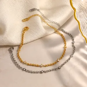Primo piano di bracciali in acciaio inossidabile oro e argento con zirconi incastonati