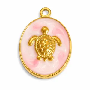 Macro detail of a 3D golden sea turtle pendant featuring pink marbled enamel inlay