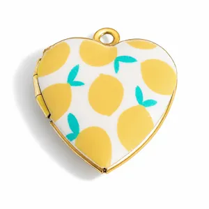 Close-up of heart-shaped gold locket with vibrant yellow lemon enamel print detail