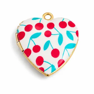 Macro detail of heart locket featuring vibrant red cherry print and gold trim
