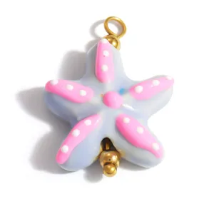 Close-up of a cute blue and pink starfish pendant with white polka dots for DIY jewelry making.