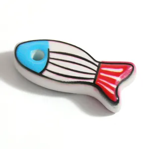 Detailed macro view of colorful dripping oil enamel fish charm for DIY jewelry.