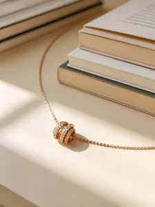 Detalle de un collar de plata S925 oro rosa con un colgante de barril de pavé brillante.