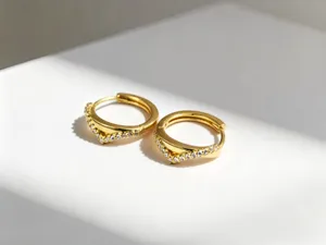 Macrobeeld van minimalistische V-vormige zilveren oorringen met fonkelende zirkonia's