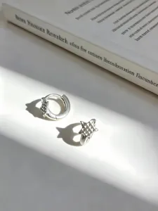 Primer plano de pendientes de aro con estrella de plata S925 con sombras solares