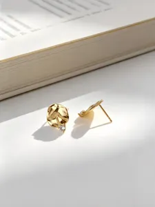 Detalle de pendientes de plata S925 bañada en oro con textura arrugada y circón brillante