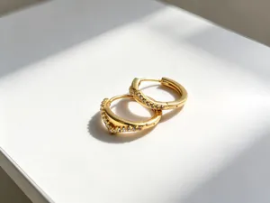 Gedetailleerde opname van elegante gouden V-vormige huggie-oorbellen met pave-zirkonia