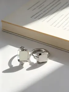Primo piano di orecchini a cerchio quadrati in argento S925 con intarsio in resina