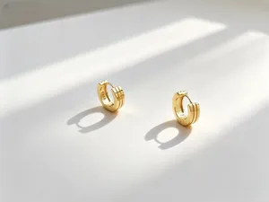 Primo piano di orecchini a cerchio in argento S925 dorati con eleganti ombre lineari