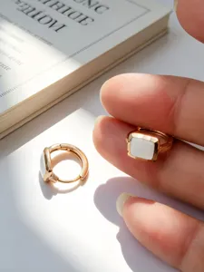 Primo piano di eleganti orecchini a cerchio quadrati in argento S925 dorato.
