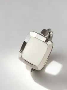 Primo piano di un orecchino a cerchio in argento S925 con smalto bianco quadrato
