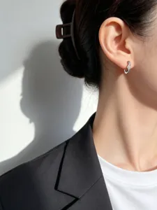 Detailopname van elegante V-vormige S925 zilveren oorringen met zirkonia stenen bij een model