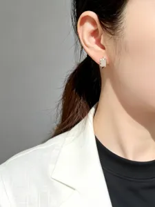Primo piano macro di un orecchino rettangolare minimalista in argento sterling S925 indossato