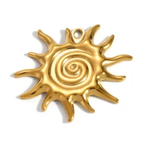 Dettaglio macro di un ciondolo a sole in acciaio inossidabile placcato oro con spirale.