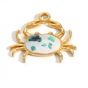 Macro view of a golden crab pendant accessory featuring white shell inlay and flakes