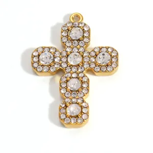 Detailed macro shot of gold-plated stainless steel cross pendant with clear crystals
