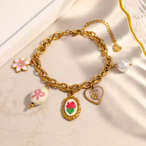 Close-up of gold-plated stainless steel charm bracelet with vintage flower and heart pendants