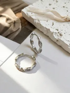 Detailansicht der minimalistischen S925 Silber Creolen mit Wellenrand und Steinen.