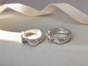 Dettaglio ravvicinato di orecchini a cerchio in argento S925 con design geometrico